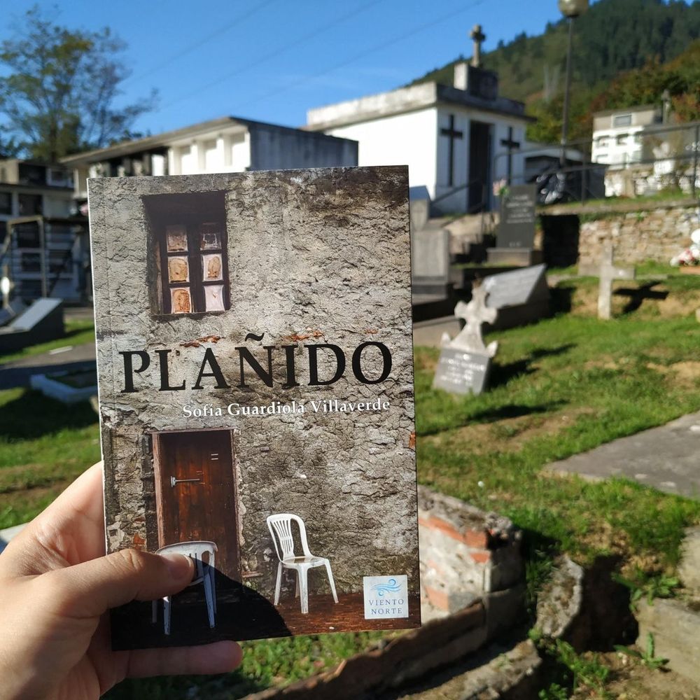 Foto de un ejemplar físico de Plañido. Al fondo, un cementerio.