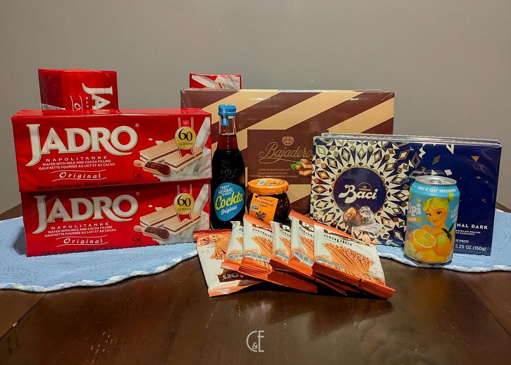 A photo of Croatian snack haul.
The photo includes 4 large packs or Jadro Waffers, 1 (of 48) Pipi cans, 1 (of 24) Cockta bottles, 1 jar of fig spread, 2 boxes of Baci chocolate, 3 boxes of Bajadera Nougat chocolates, and 6 small bags of Slani Stapici pretzel sticks.
