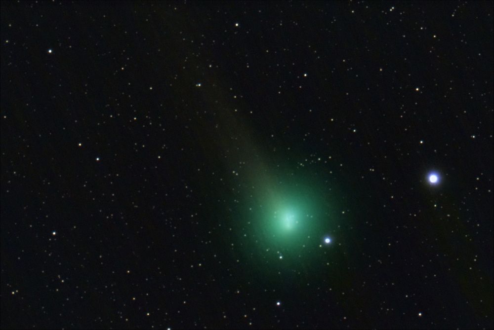 A bright comet with teal glow. A faintly visible tail going up and to the left. There's a very bright star to the right.
