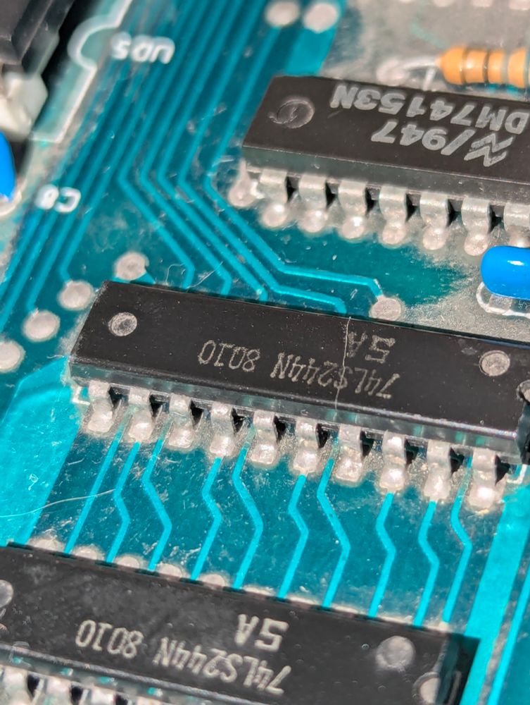 A picture of a 74LS244 integrated circuit on the PET motherboard. The chip has a visible crack around two thirds of the way along to the right.