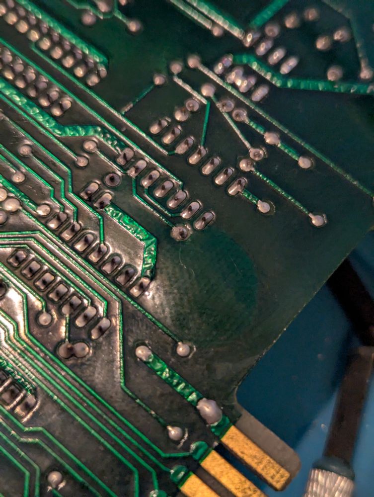 A picture of the bottom of the PET motherboard. A raised lump is visible on the board indicating that the board is delaminating..