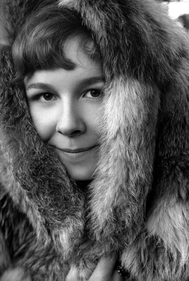 A black and white photo taken in 1972 of the British singer/songwriter Sandy Denny age 25.   Sandy is looking directly into the camera, and has pulled a fur hood over her head.   Copyright 2008 the Estate of Keith Morris