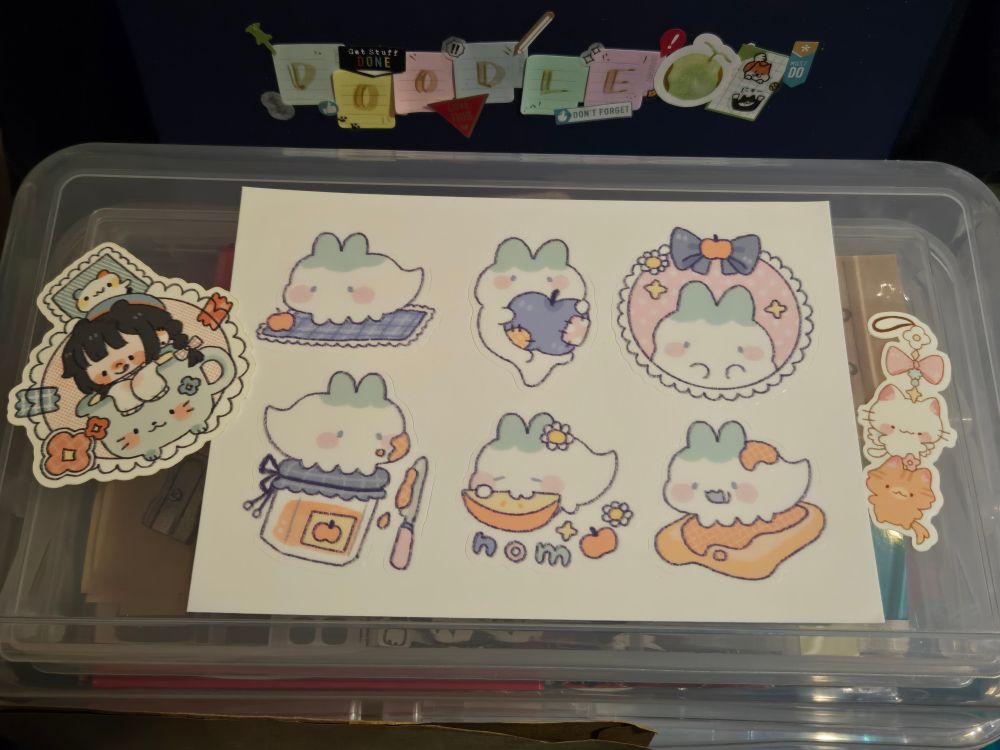 Alternate angle of all the stickers. It's sitting atop my stationary storage containers, and my doodle binder is seen behind it.