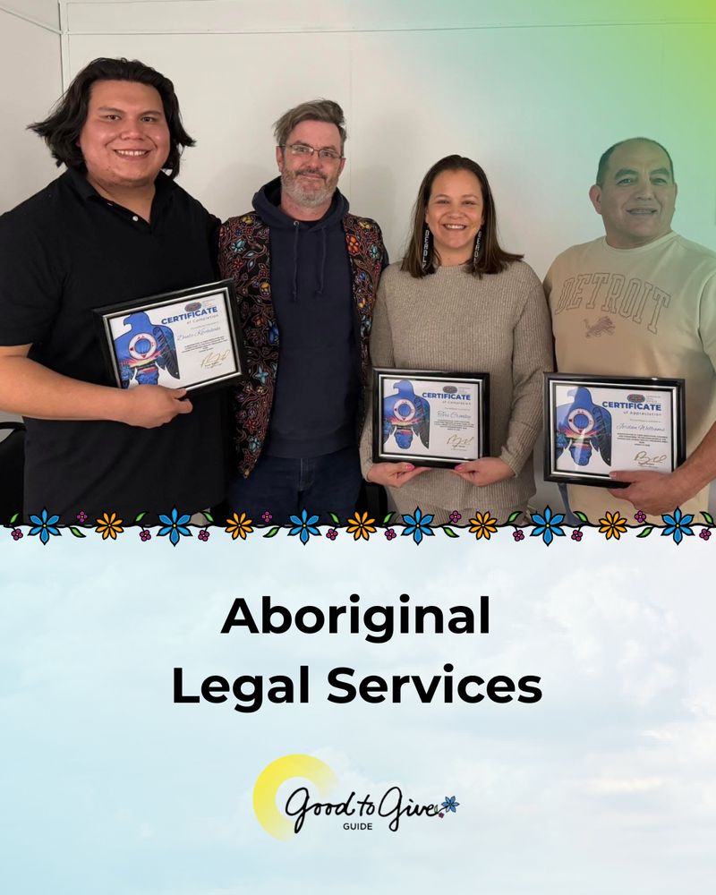 Photo of four people standing and posing for a photo. Three are holding framed certifcates. Aboriginal Legal Services. Good to Give Guide logo.  