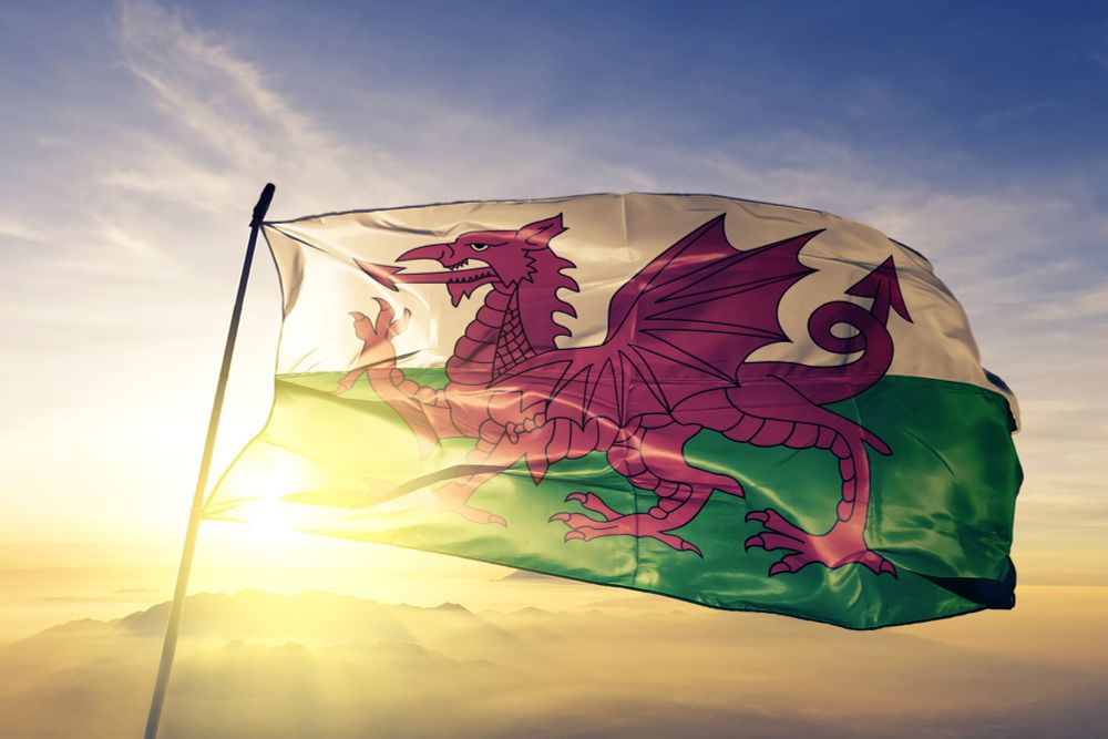 A flag with a Welsh dragon flying in the sunset.