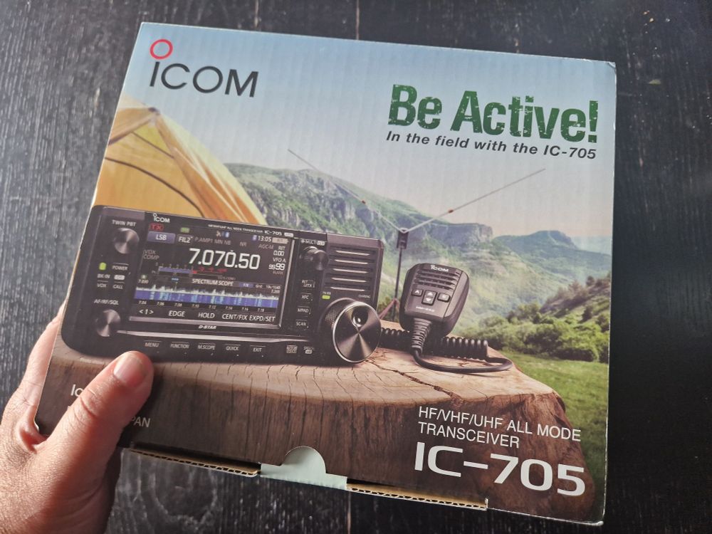 Box of Icom ic-705 with a hand hold it.