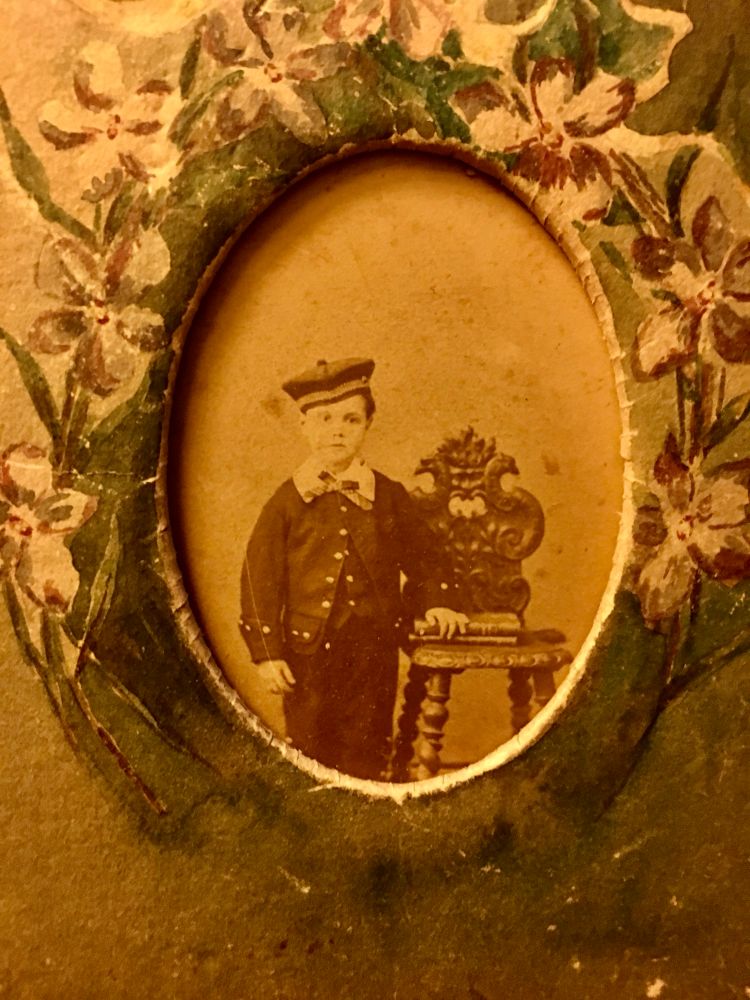 A sepia-toned studio photo of a little German boy in late 1800s.