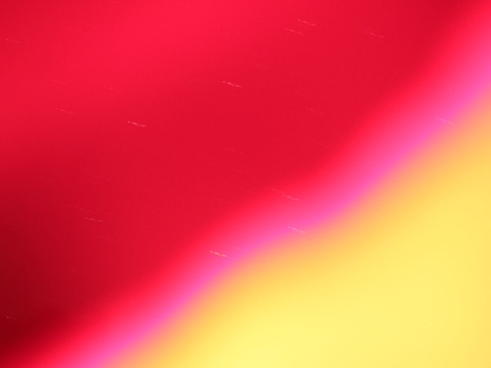 A large red blur in most of the left and upper section, with a yellow blur in the bottom right corner. The pink in between shows a couple of light streaks also, which are stars