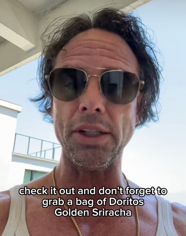 A brilliantly deranged looking Walton Goggins in tank top and sunglasses says "check it out and don't forget to grab a bag of Doritos Golden Sriracha.