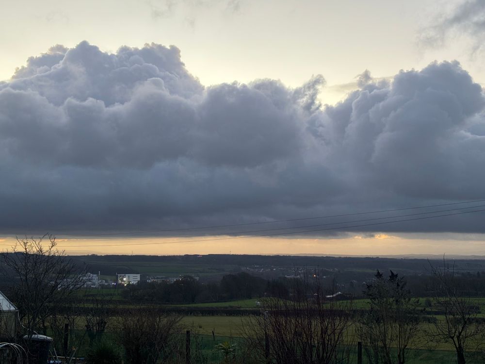 Cumulus/Stratocumulus clouds presaging rain over green fields morning view 