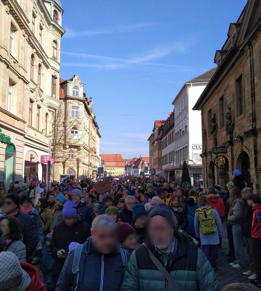 Rückblick über den Demozug zwischen Gebäuden Richtung Kettenbrücke. Es sind viele Menschen aller Altersgruppen zu sehen