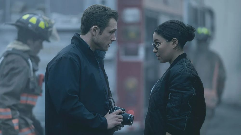taron egerton and jurnee smollet in front of a fire truck