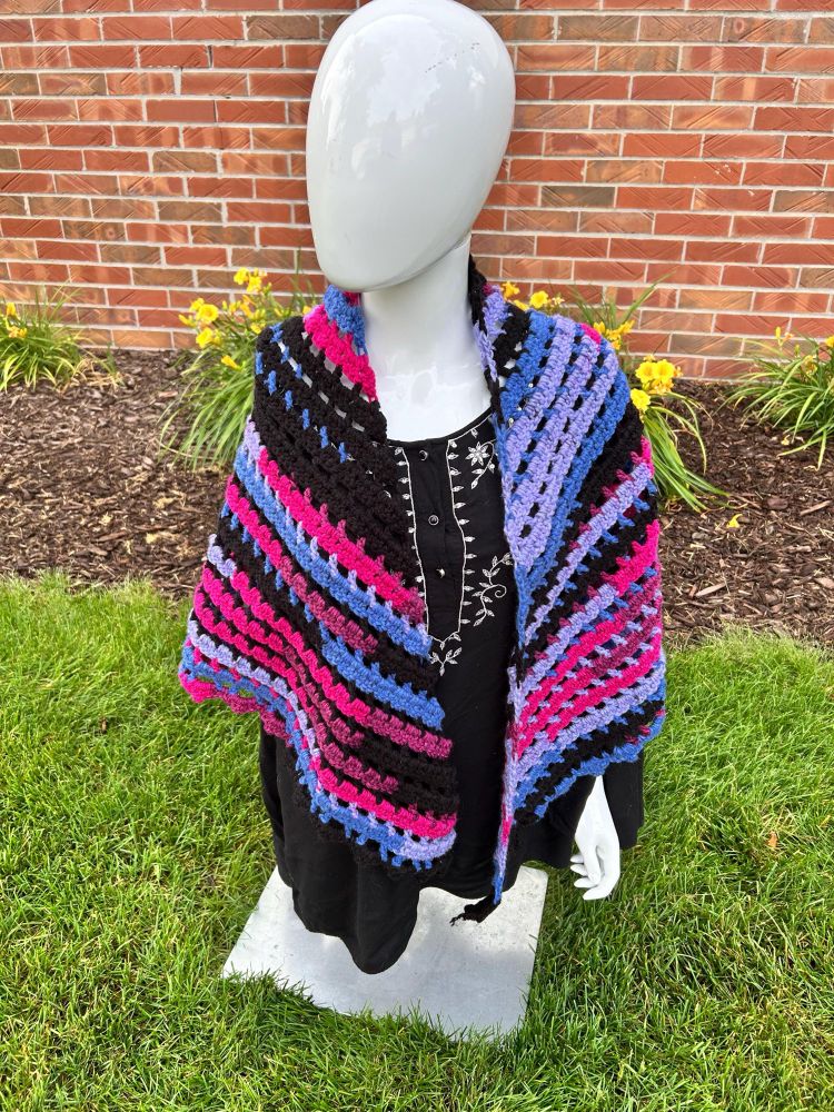 Crochet pink/blue/black shawl on a mannequin 