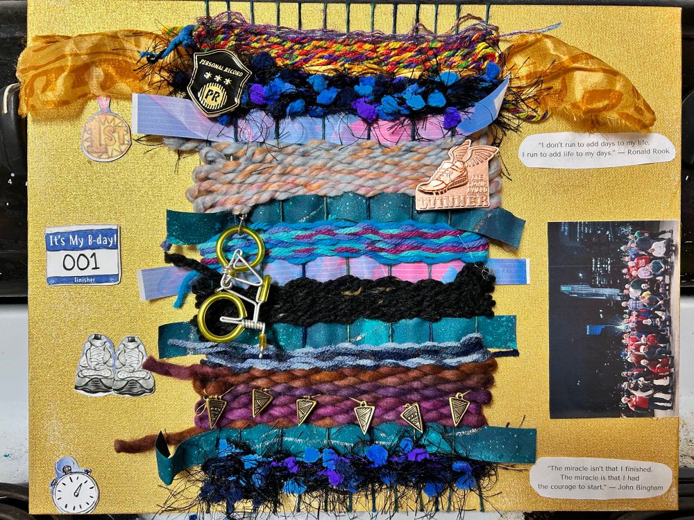 A weaving with yarns and ribbons in blues, purples and black on a gold painted canvas board. The weaving has a bike keychain, gold triangle charms and running pins attached. Collaged around the weaving are images related to running. Quotes, a race bib, shoes, stopwatch, medal and group photo. 