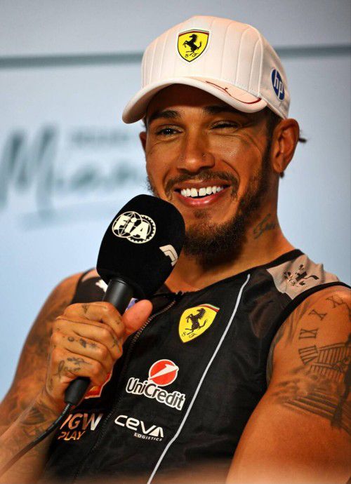 Lewis hamilton holding a microphone and smiling at the post-sprint press conference at the 2025 Miami Grand Prix 