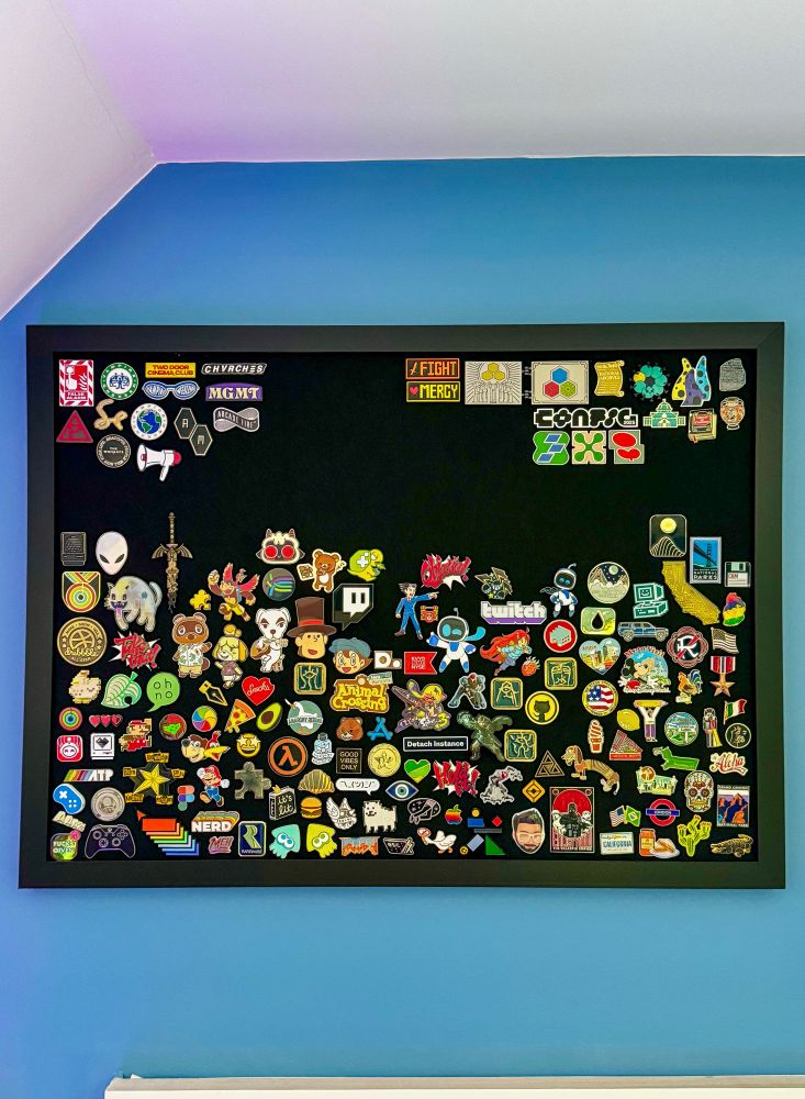 An image of a black pin board, filled with pins (but with space left)