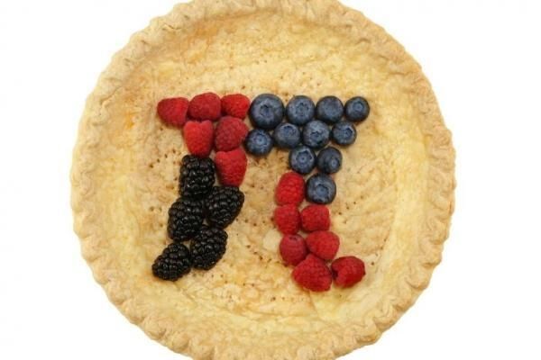 A top down view of a pie with mixed berries in the shape of the symbol for pi