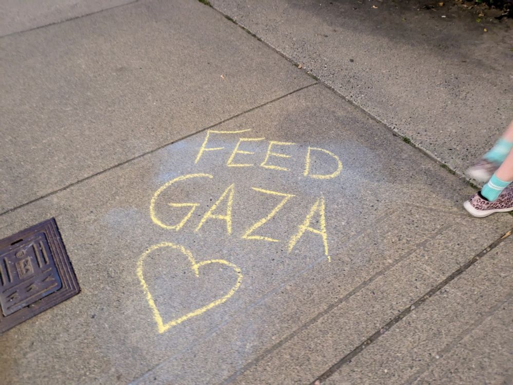 Chalk words on sidewalk FEED GAZA
