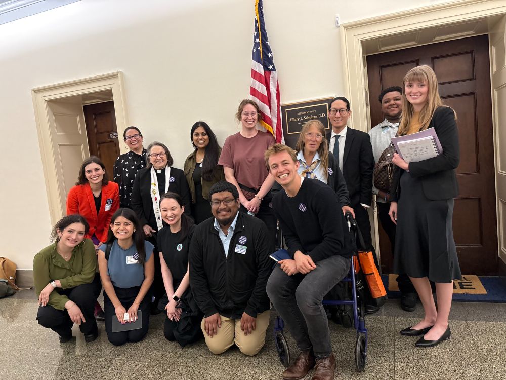 A diverse group of people are posing for a photo in from of Rep. Scholten's office inside the US capitol.