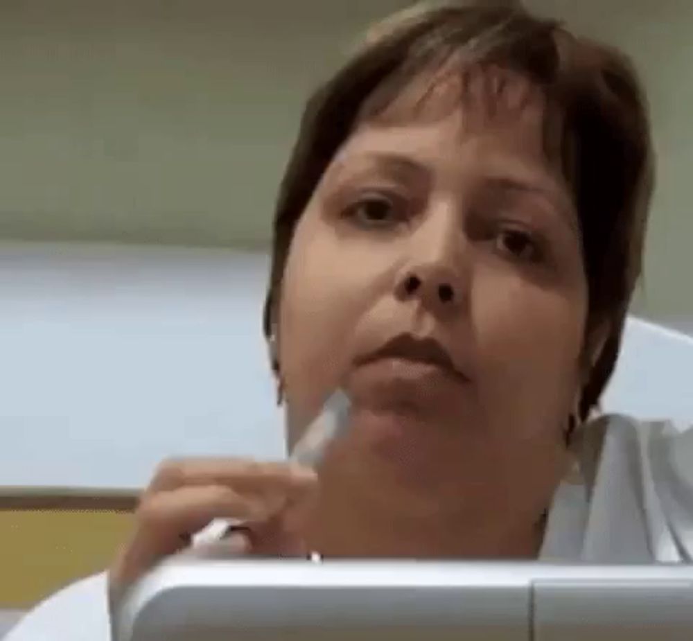 a close up of a woman 's face while holding a syringe in her hand .