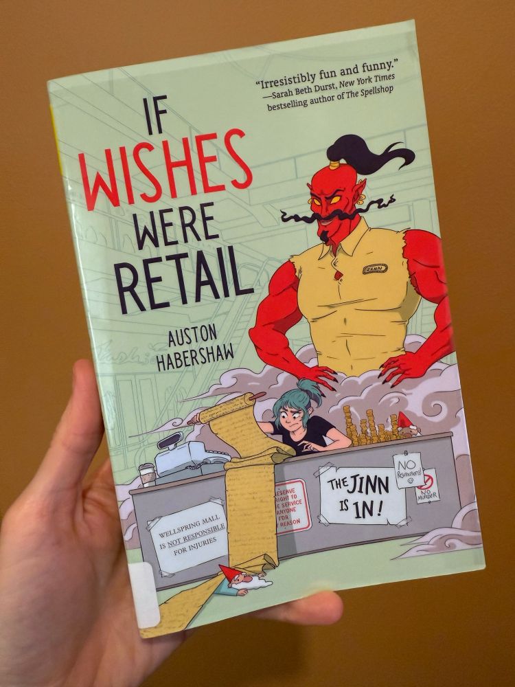 A whimsical cover features jinn looming over a busy blue haired woman at a desk.