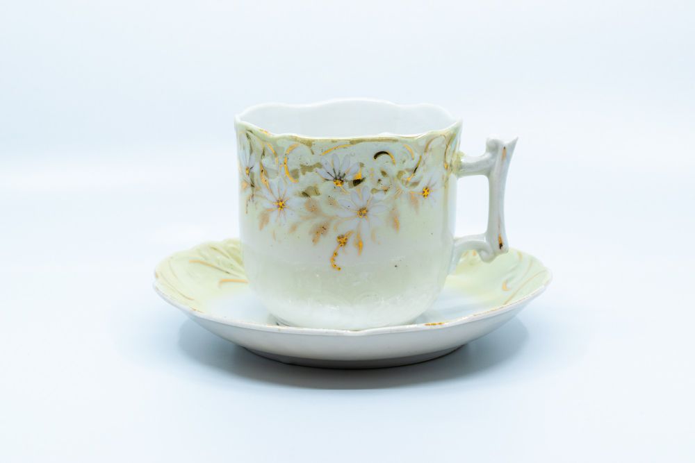 An antique teacup with a gold flower pattern
