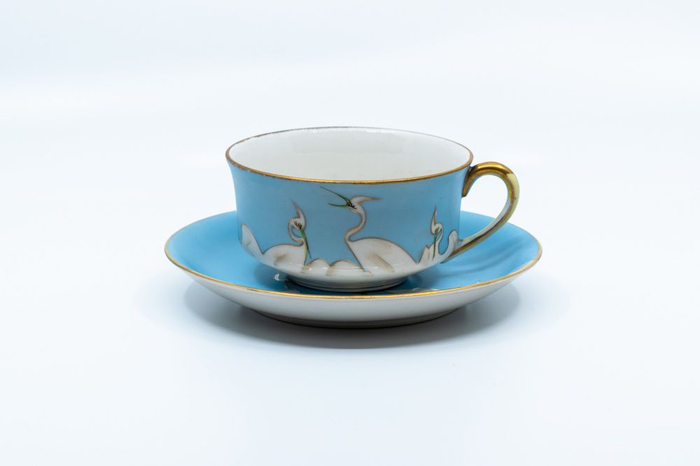 An antique teacup with white swans