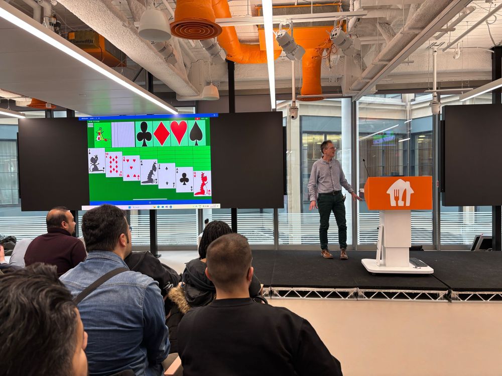 Guy Barker on stage in the background and some of the attendees in the foreground. On the shared screen we can see Guy’s accessibility solitaire game.