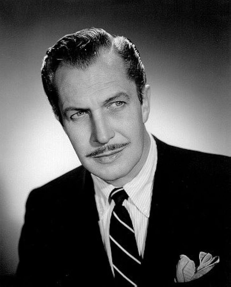 A black and white photo of a dapper white man with a mustache.