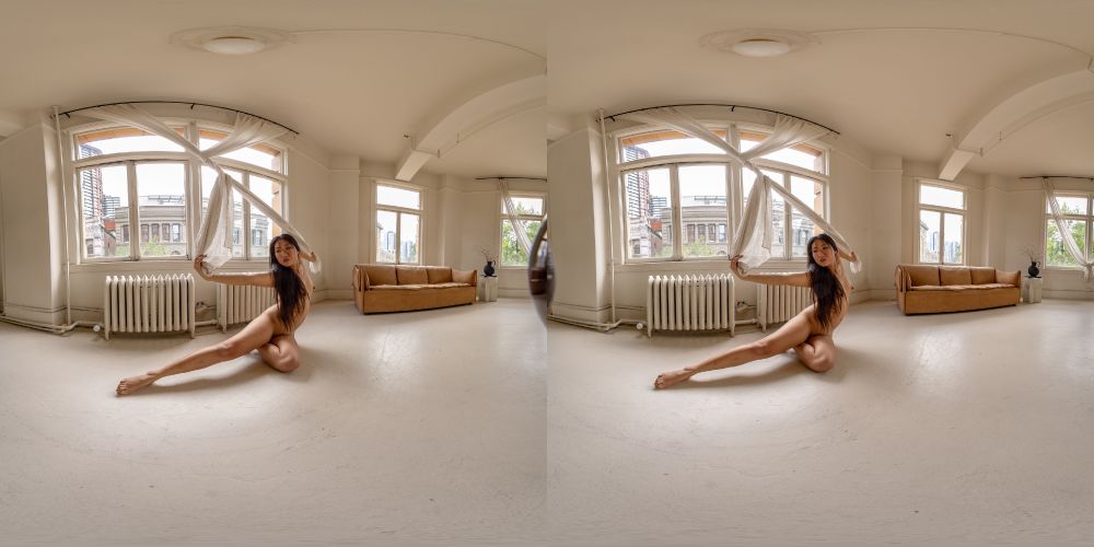An equirect picture of model Minh-Ly posing nude on the floor, holding a twisted curtain.