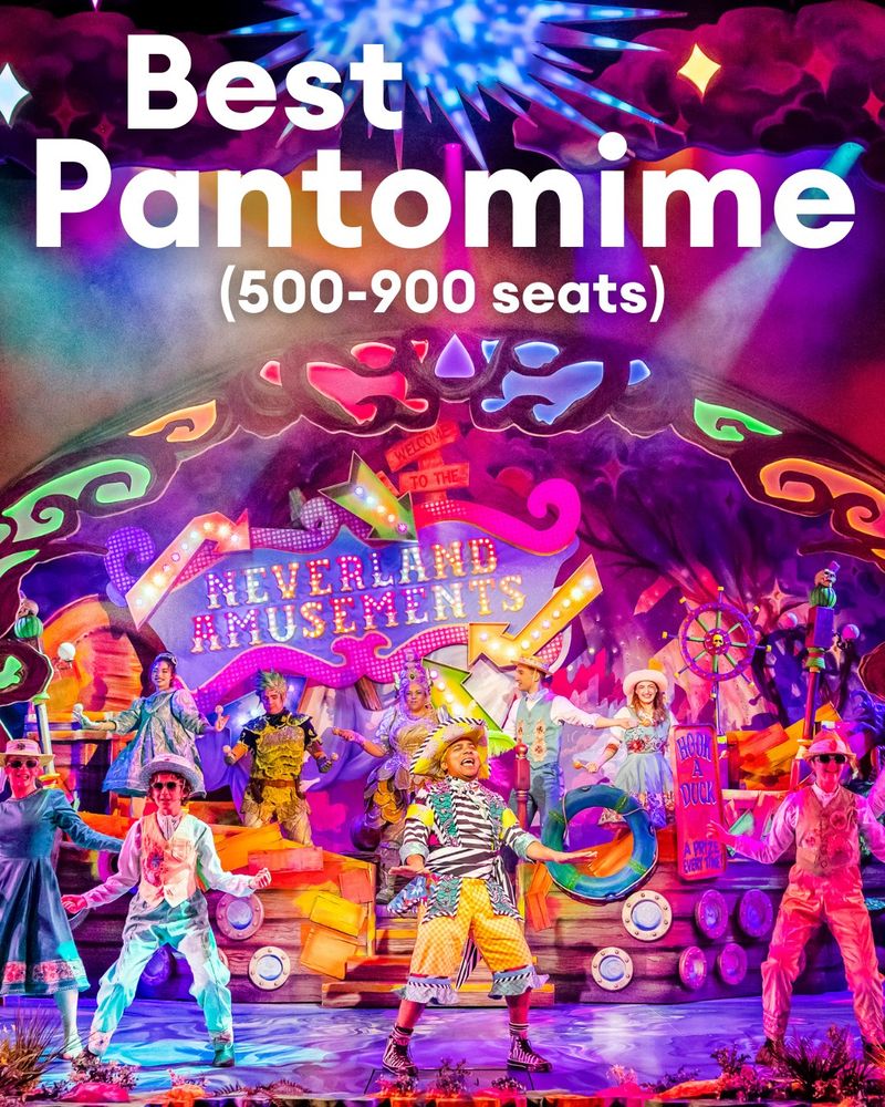 An image of Dale Superville dressed as a very colourful pirate, with a light up "Neverland Amusements" boat behind him and he's accompanied by the Peter Pan cast. At the top of the image is the text "Best Pantomime (500-900 seats)