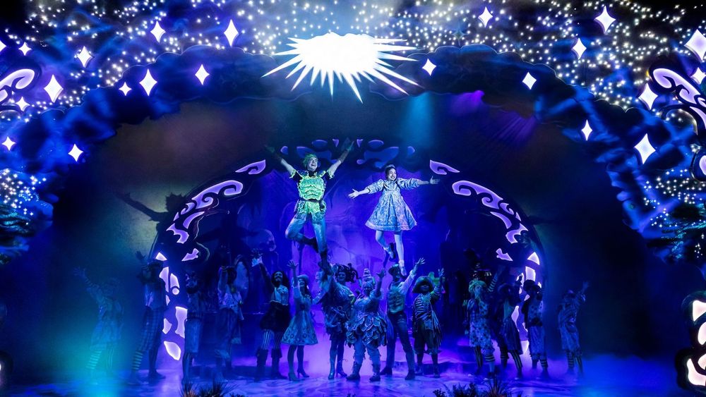 Peter Pan and Wendy take flight above the ensemble.