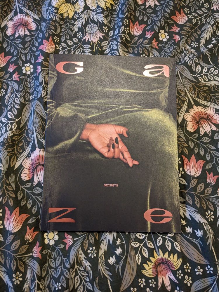 La couverture du numéro 7 de la revue Gaze. On y voit une main posée sur un drap de velours vert, qui croise les doigts. Le thème du magazine sont les secrets.