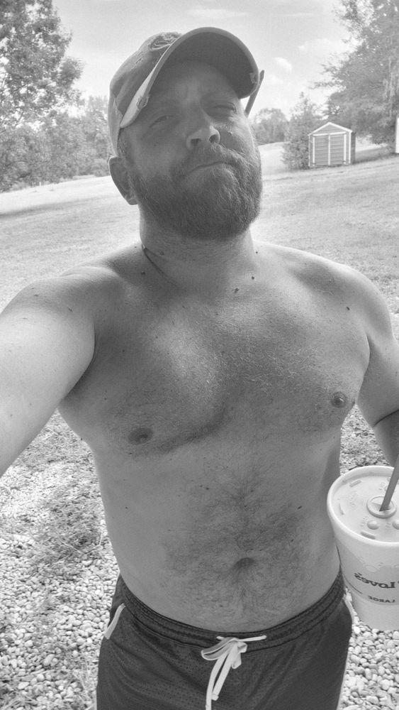 Shirtless guy outside. Holding a cup. Pencil behind his ear. Kinda slutty. 