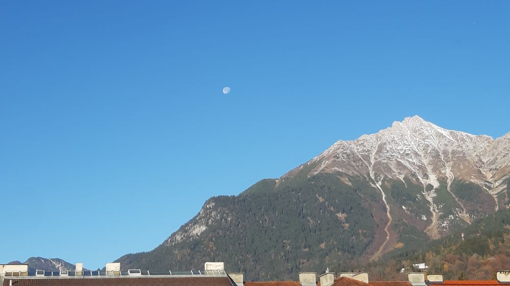 Mond abnehmend, wolkenloser Himmel, sonnenbeschienener Berg - "Brandjoch".