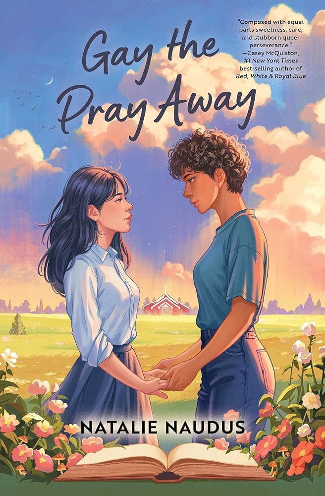 Book cover reading “Gay the Pray Away.” The cover image shows two teen girls holding hands and looking into each others eyes. The girl on the left has long black hair and light skin, and is wearing a white button up shirt and dark colored skirt. The girl on the right is taller and has short curly brown hair and darker skin, and is wearing a green t-shirt and jeans.
