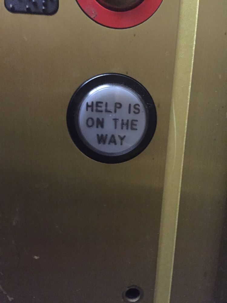 Elevator button that reads “HELP IS ON THE WAY