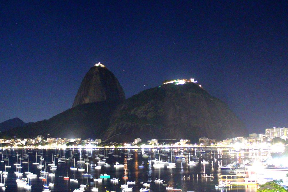 Morro do Pão de Açúcar a noite com vários barcos no mar em Botafogo 