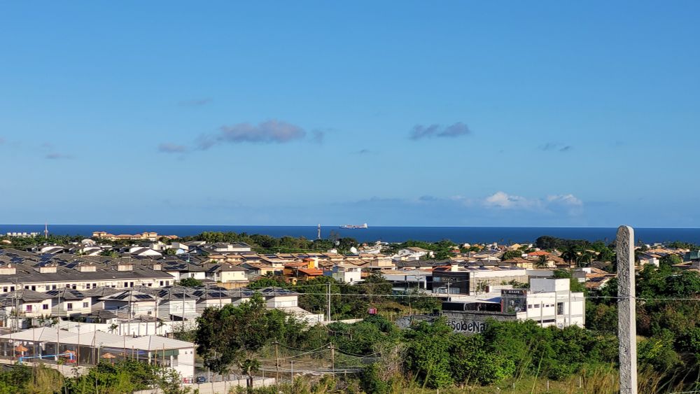 Varias casas, o mar e um céu azul. 