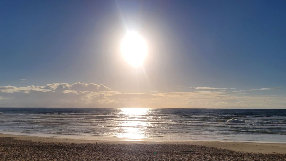 Sol sobre o mar em um céu azul 