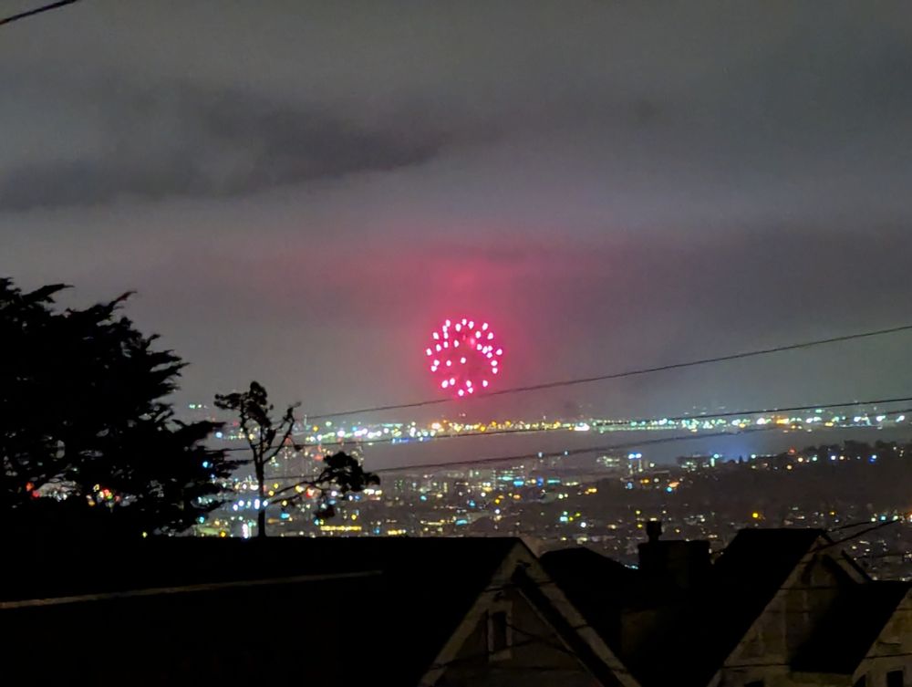 Fireworks in the distance, seen from a hill above the skyline and amazingly not covered in fog