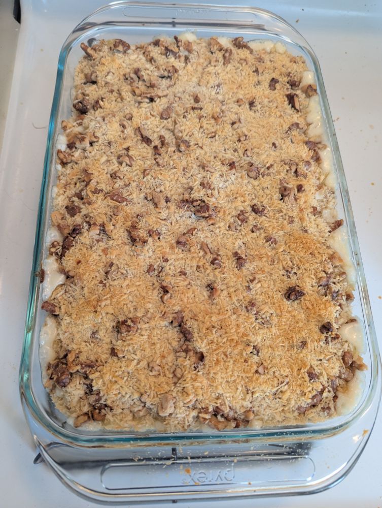 9×13 baking dish filled with macaroni and cheese with visible walnuts and panko topping