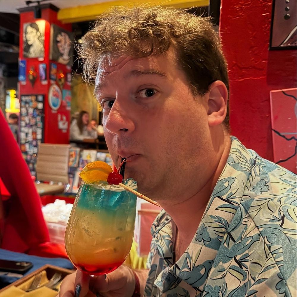 Me sipping a rainbow layered cocktail