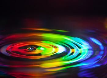 A rainbow effect is applied over a ripple in the water, symbolising the ripple effect