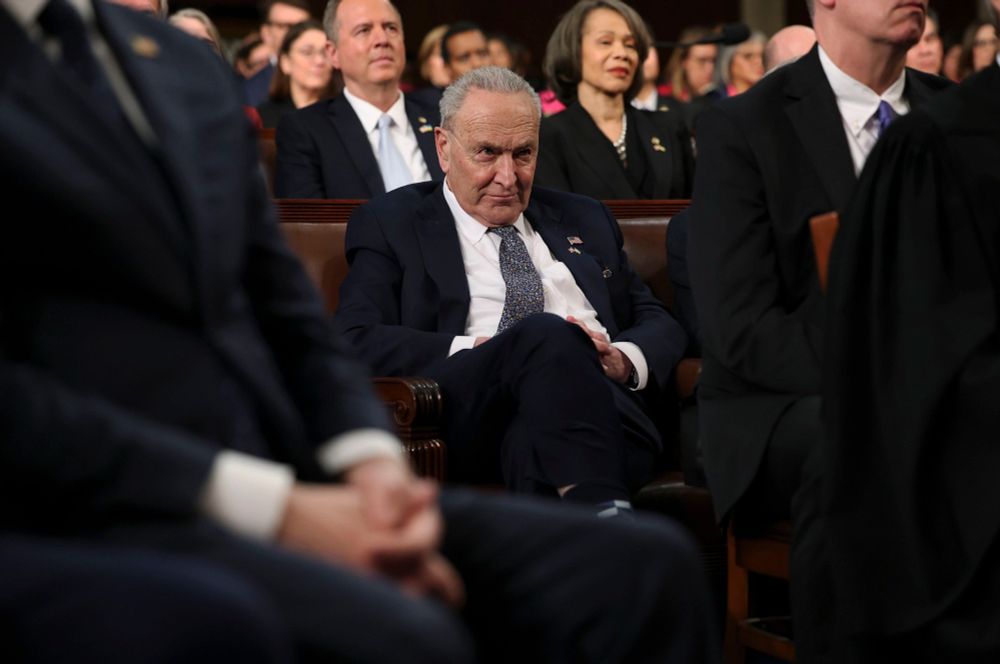 Photo of Schumer hunched over looking pathetic and miserable as Trump holds a campaign rally inside Congress.