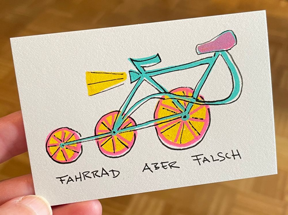 Zeichnung: Eine Art Fahrrad mit drei Rädern in einer Reihe und dem Sattel ganz hinten. Schrift: Fahrrad aber falsch