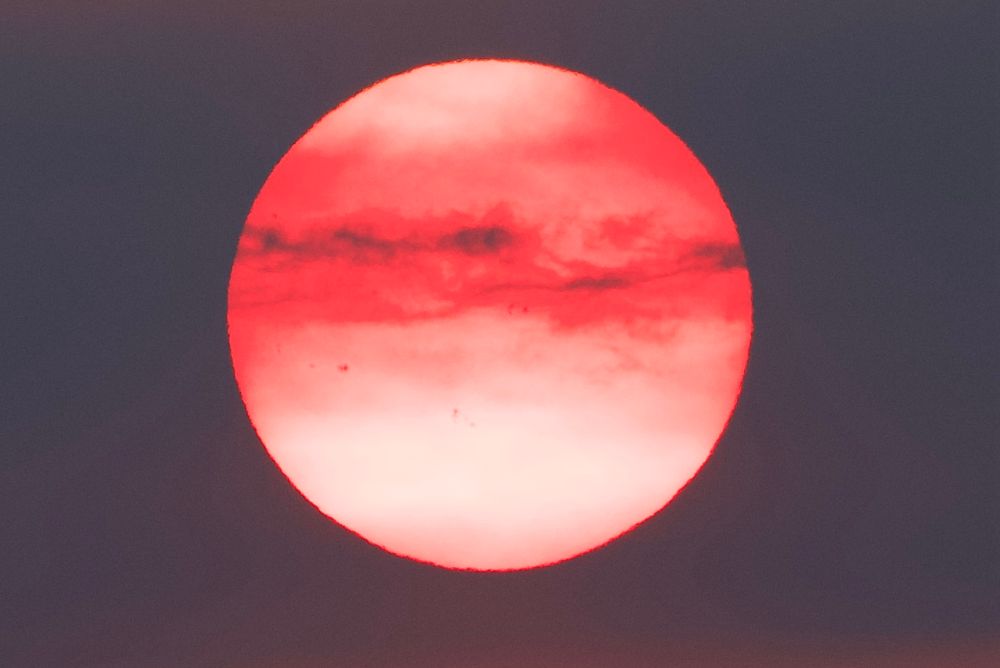 A fiery red sunset through wildfire smoke over the Salish Sea