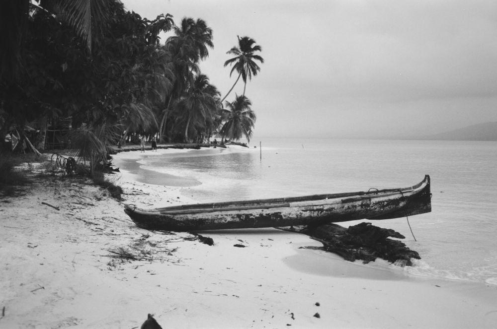 A hand carved canoe on the beach of an island 