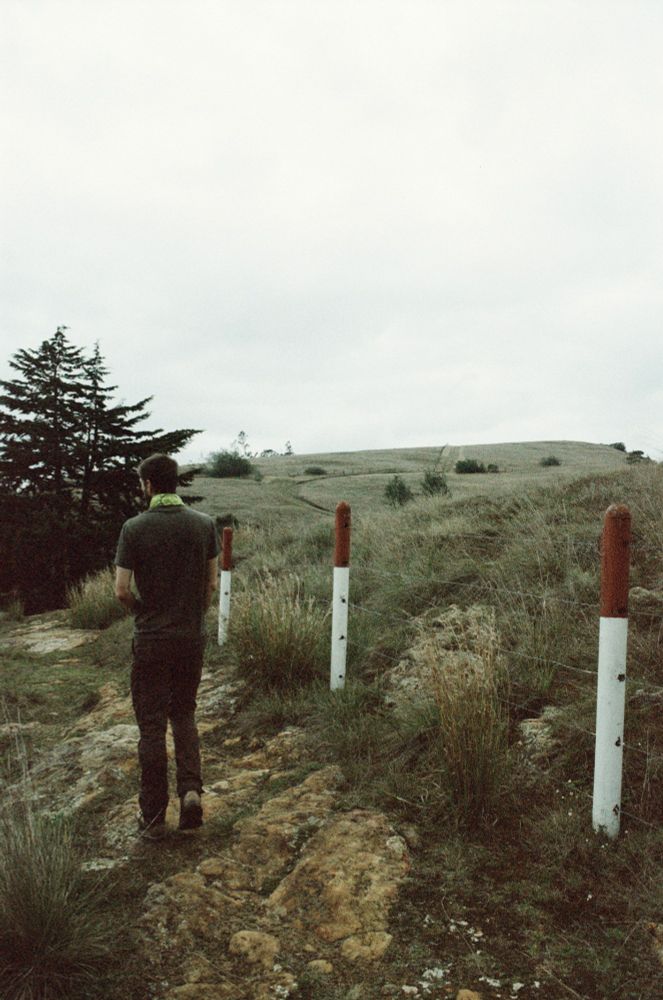 Man walks along fence
