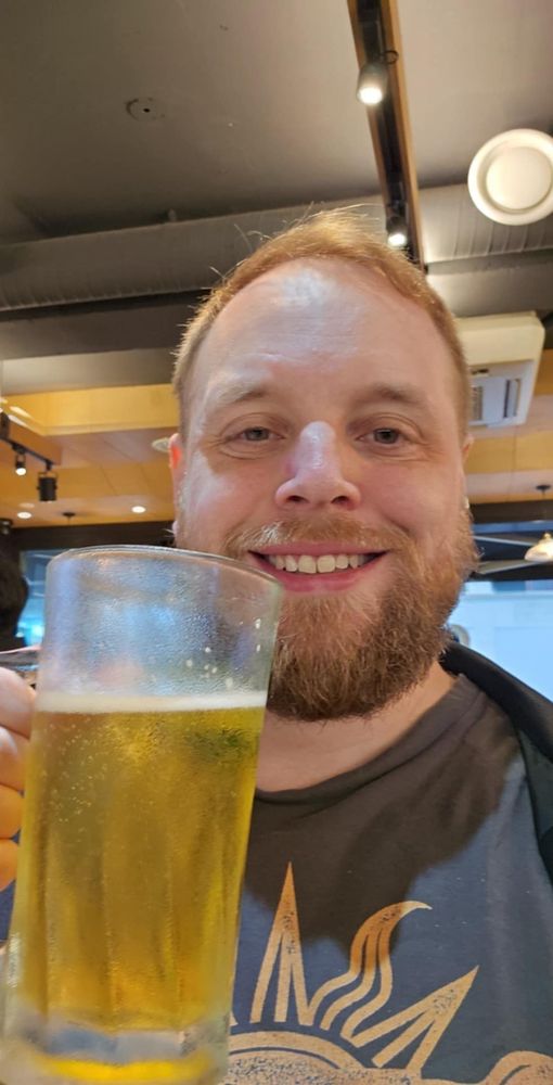 Selfie på blupparen brukspatron med en öl i handen. Han ler och ser kär ut.